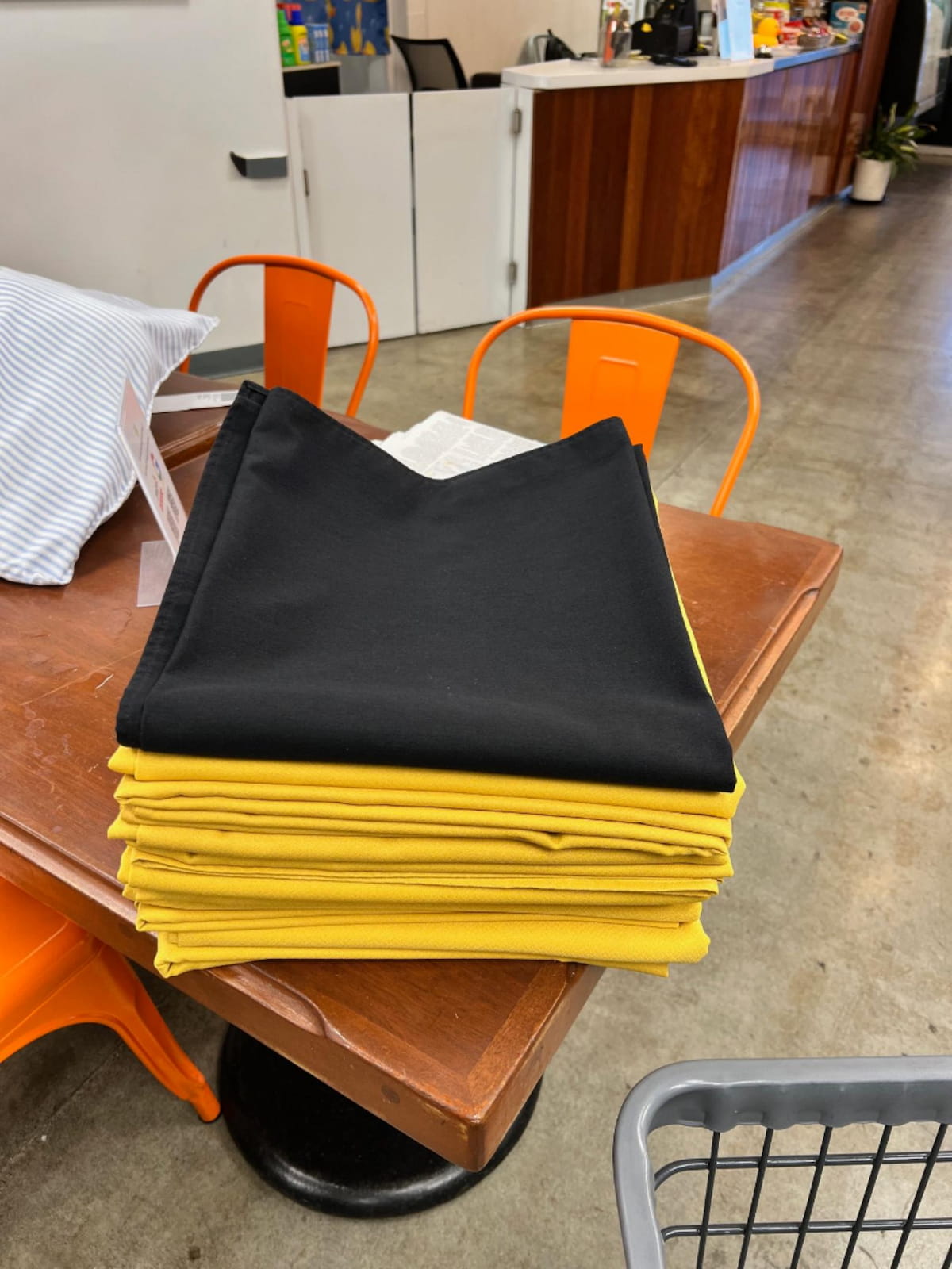 Neatly stacked dry-cleaned tablecloths at Bims Laundry Cafe in Everett, WA