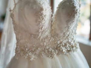 Close-up of a lace wedding gown professionally dry cleaned and preserved by Bims Laundry Cafe in Everett